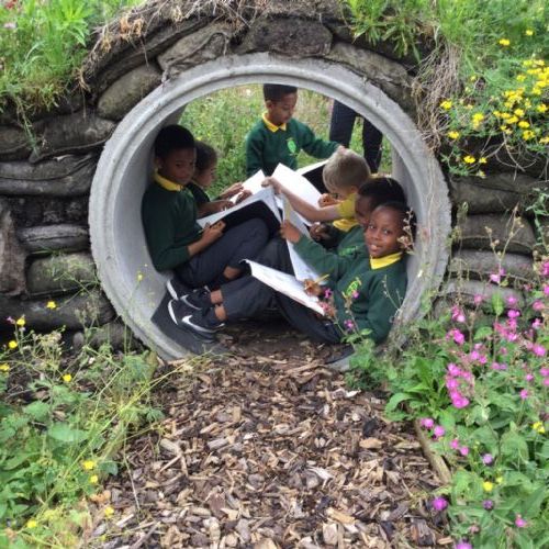Children Reading and Writing in a Garden